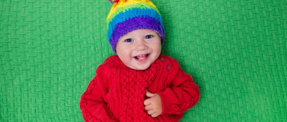 Baby with knitted sweater, toque and blanket