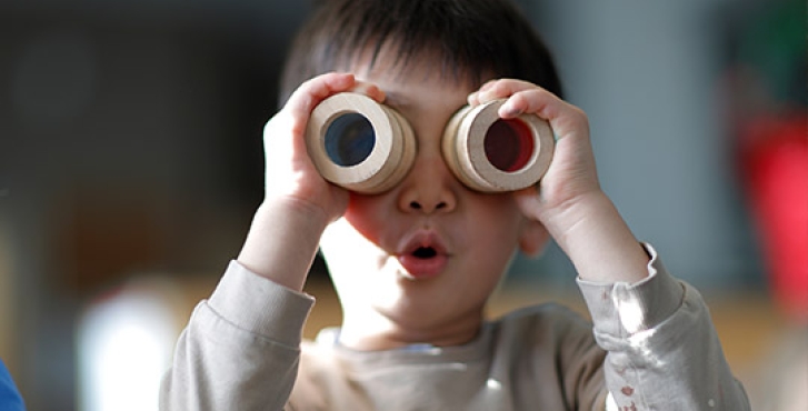 Little boy looking through toy goggles