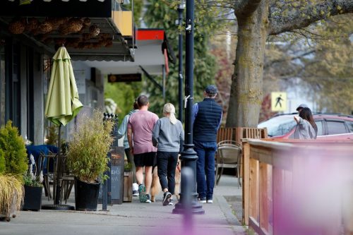 Residents walk down a street in Estevan Village in Oak Bay, lined with Oak Bay Businesses.